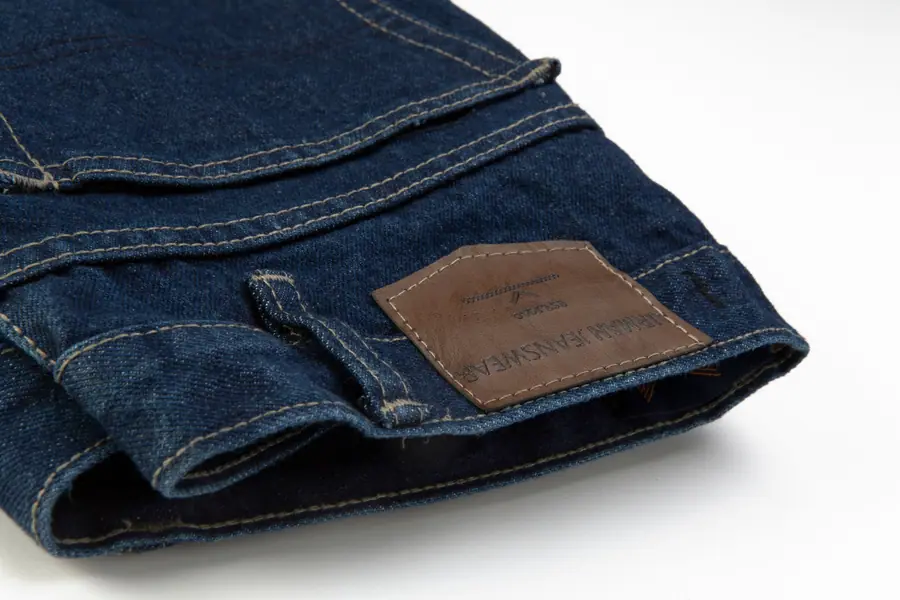 Detalle de parche y costuras de pantalón de mezclilla